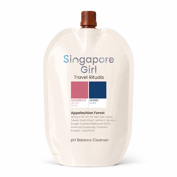 A single-serve refill pouch of Singapore Girl Travel Rituals Appalachian Forest pH Balance Cleanser, featuring a cream-colored body, a brown cap, and a color block label with pink and blue swatches.